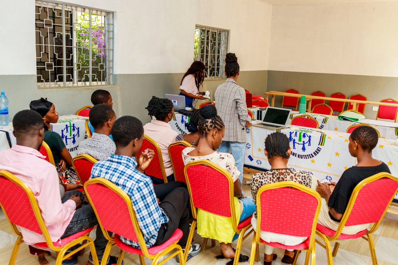 Young people in a training room with laptops set out on the tables