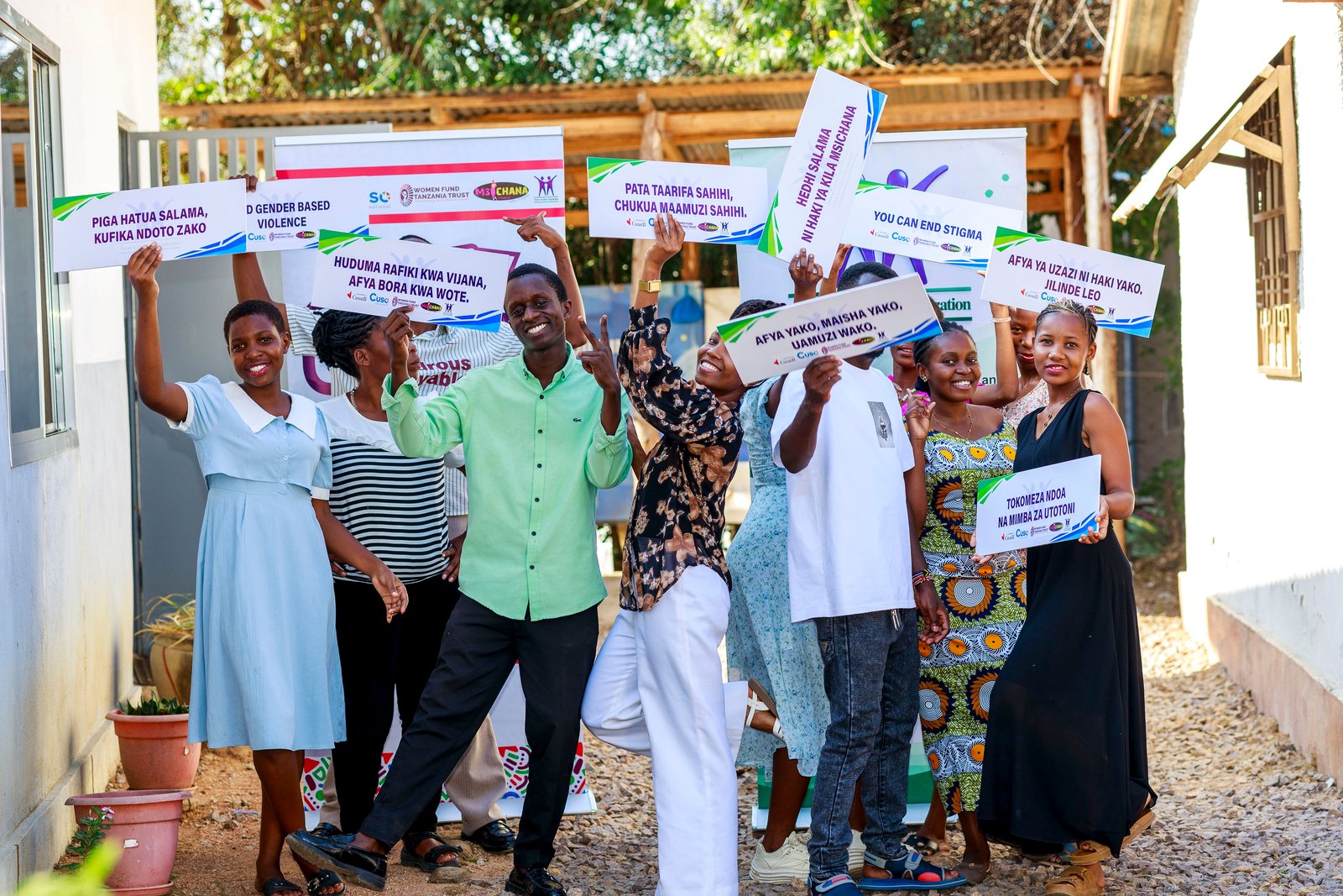 Young people raise Swahili placards against gender-based violence
