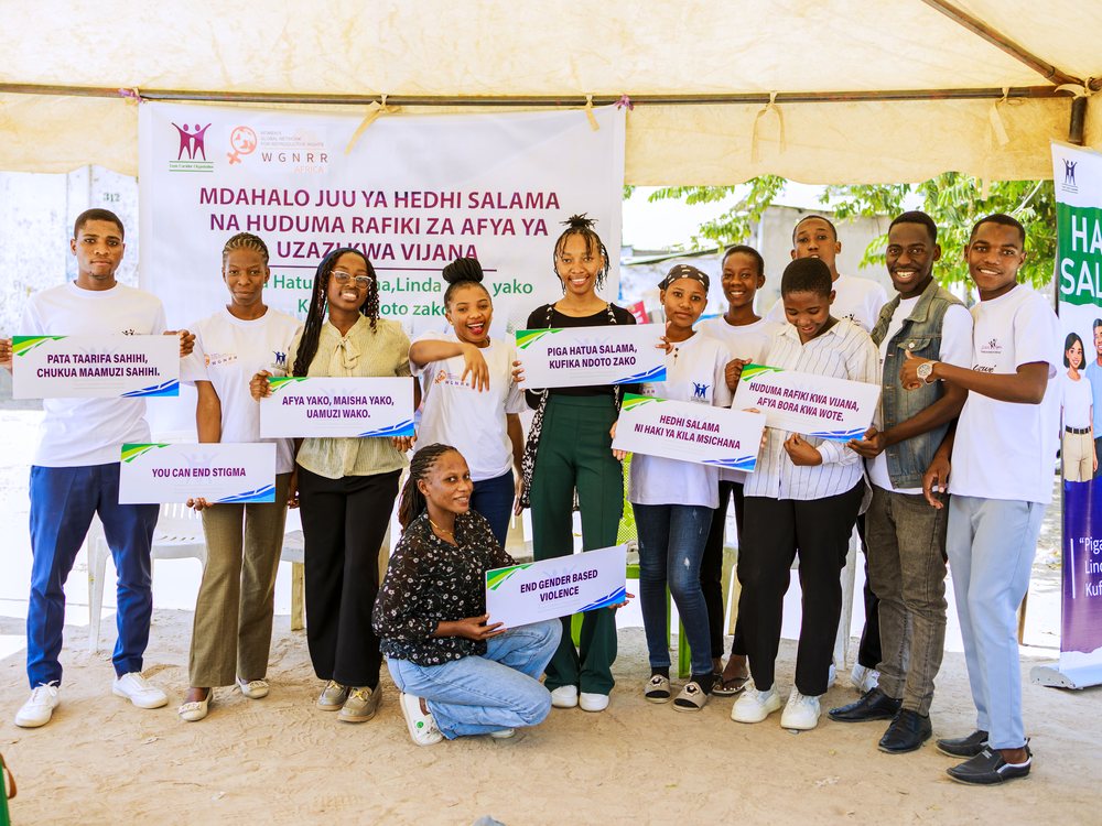 Hatua Salama peer educators and guests holding message placards